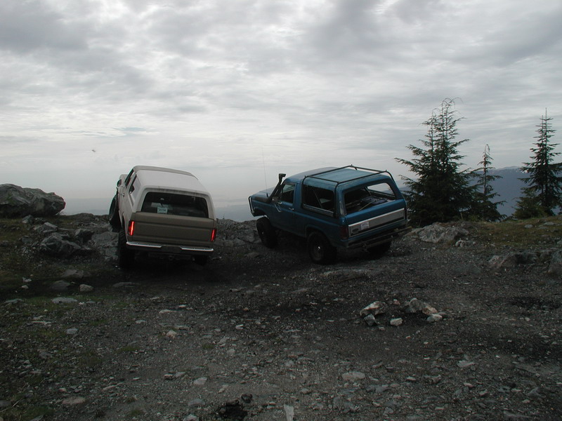 Two off-road vehicles on a rocky mountain trail.