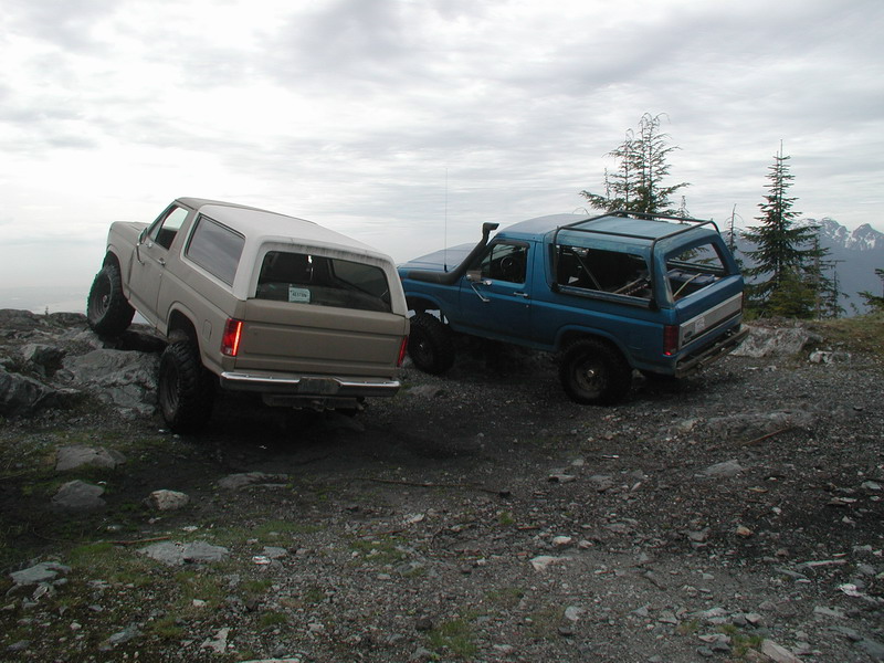 Two Ford Broncos on a rocky mountain trail.
