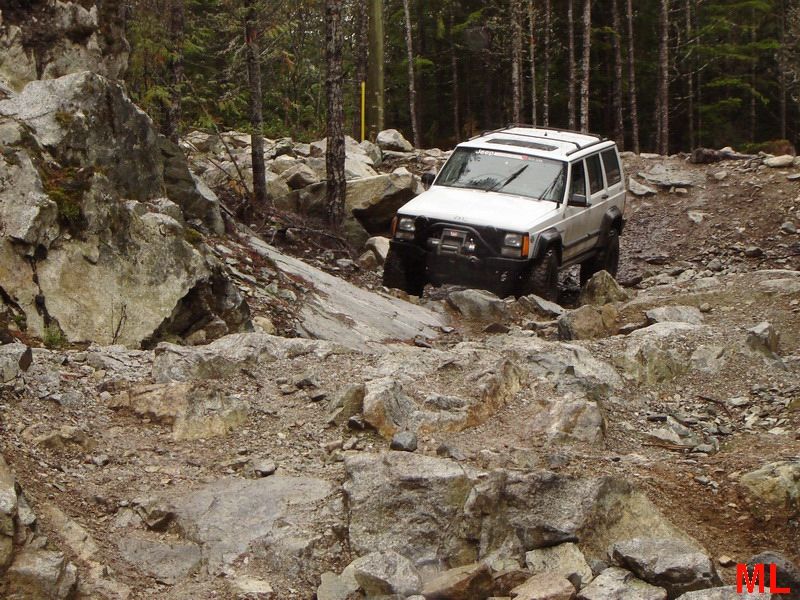White Jeep Cherokee on a rocky off-road trail.
