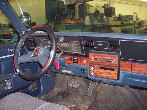 2001 Ford Crown Victoria - The interior of a blue car with wood grain accents on the dashboard and center console.