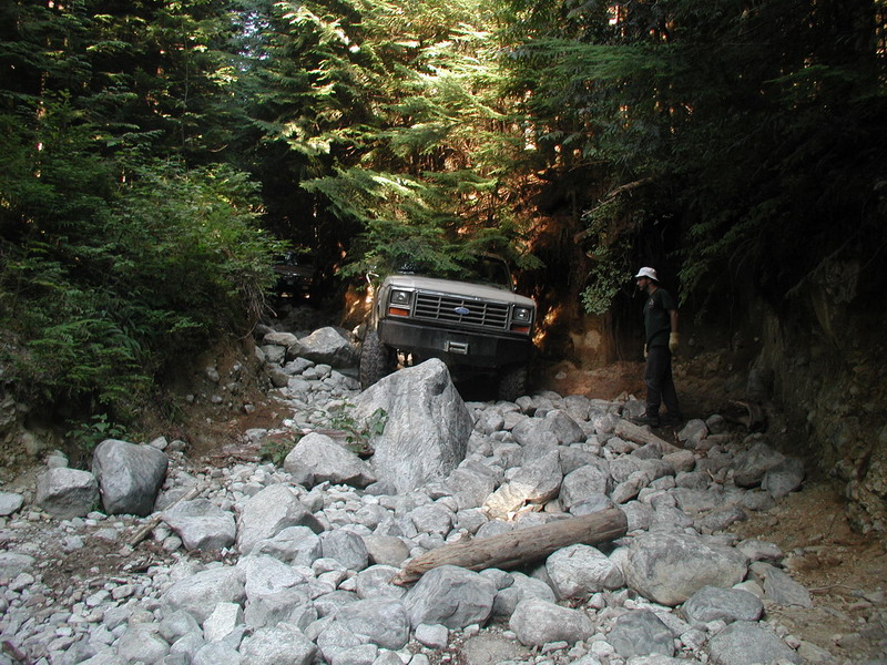 1985 Ford Bronco on a rocky, wooded trail.