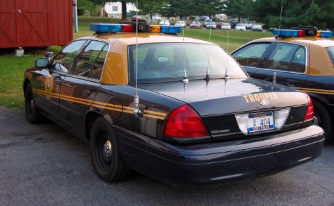 1991 Ford Crown Victoria LTD - A black and tan police car is parked next to another similar vehicle.