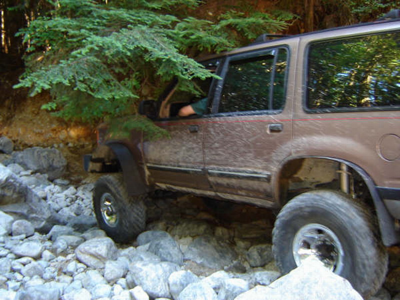 Brown SUV driving on a rocky trail
