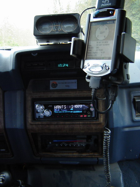 1985 Ford Bronco - The interior dashboard of a vehicle shows a GPS unit mounted above the radio, which displays the time 10:24. A JVC car stereo is visible be…