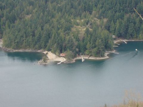 1985 Ford Bronco - A wide aerial view of a wooded coastline with several houses and docks on a body of water.