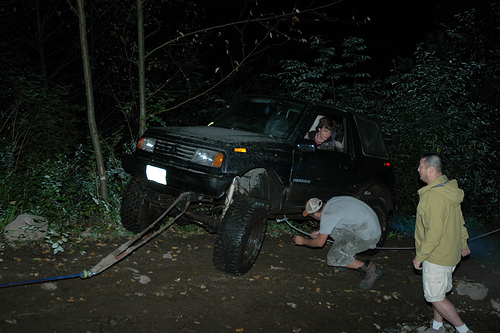 SUV being winched out of mud at night