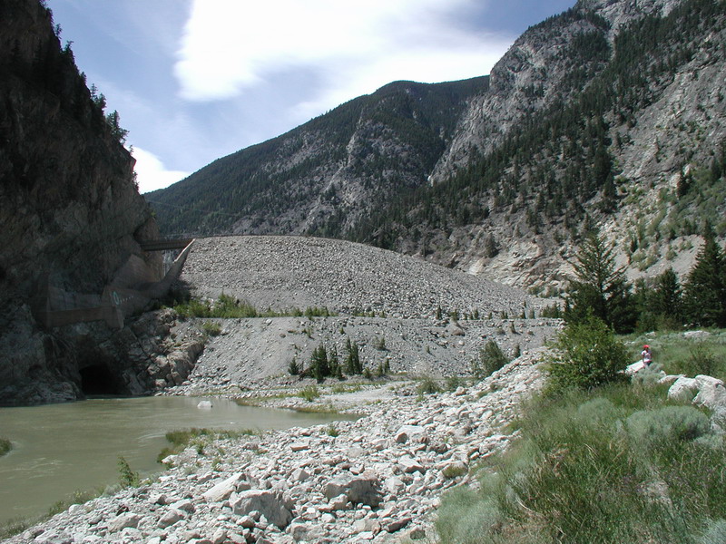 River flowing through a rocky mountain pass with a tunnel entrance.