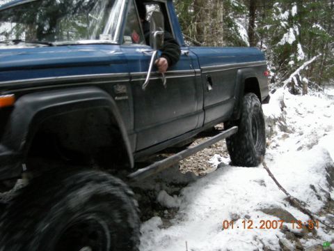 Blue and black pickup truck on a snowy trail