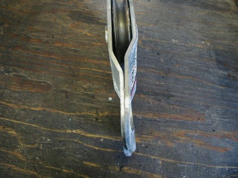 Metal pulley with hook on wooden surface