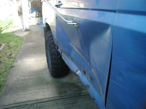 Blue SUV with significant damage to the rear quarter panel and rocker panel.
