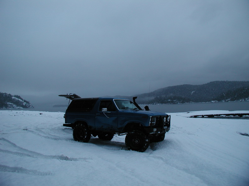 Blue Ford Bronco with large tires and snorkel in the snow.