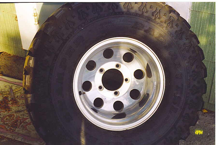 Close-up of a large off-road tire mounted on a polished aluminum alloy wheel