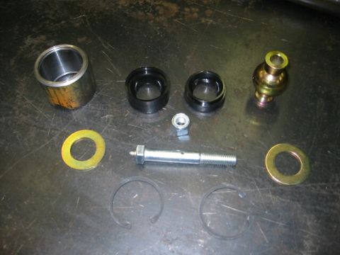 1994 Ford Bronco - Various automotive suspension components are laid out on a workbench, suggesting a repair or upgrade process.