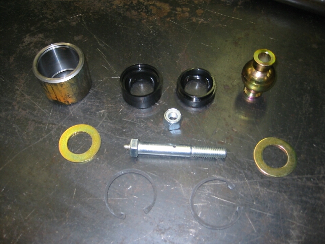 Disassembled rebuildable suspension (Johnny) joint kit parts on a bench.