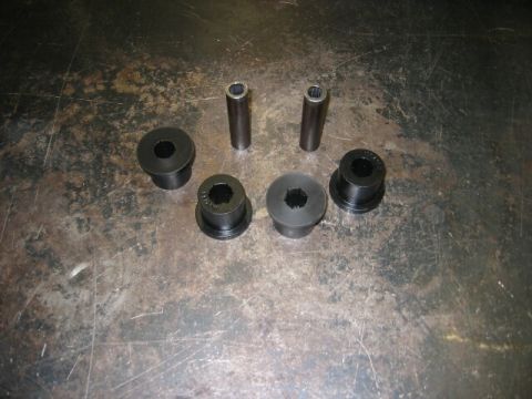 1994 Ford Bronco - New suspension bushings and sleeves laid out on a metal surface.