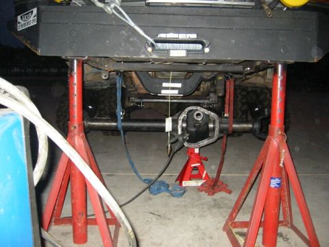 1994 Ford Bronco - The rear axle assembly is supported by jack stands as work is performed on the vehicle.
