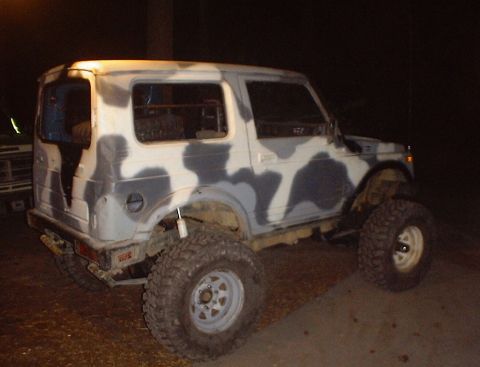 1989 Ford Bronco - This modified Suzuki Samurai is painted in a camouflage pattern and sits on large off-road tires.