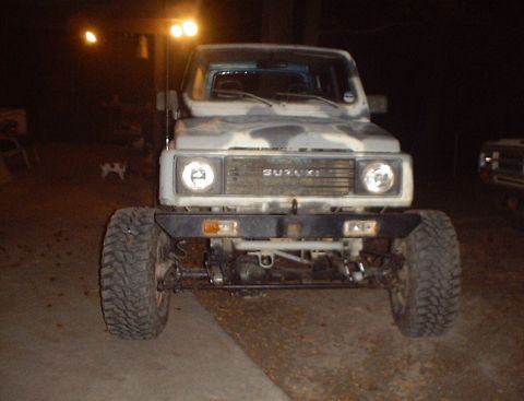 1989 Ford Bronco - Front view of a Suzuki Samurai with camouflage paint and an aftermarket bumper.