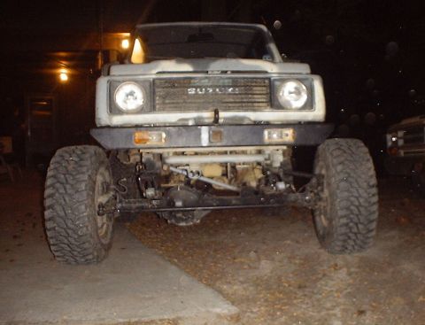 1989 Ford Bronco - This Suzuki Samurai is modified with a heavy-duty bumper and off-road tires, seen at night.