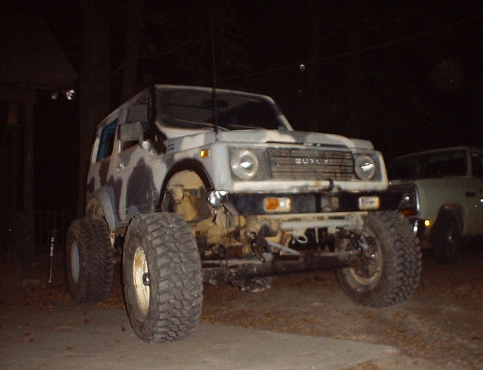 Suzuki Samurai with camouflage paint and large tires, front view