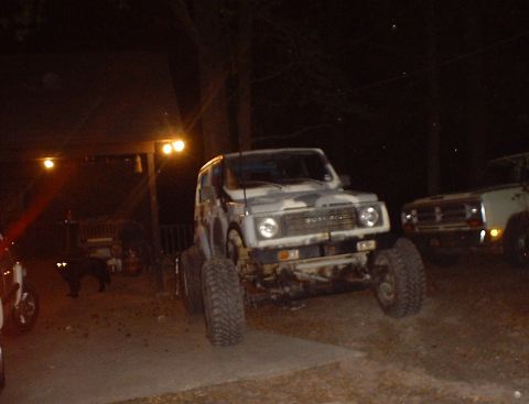 1989 Ford Bronco - A Suzuki Samurai with custom paint and off-road tires is parked next to another vehicle.