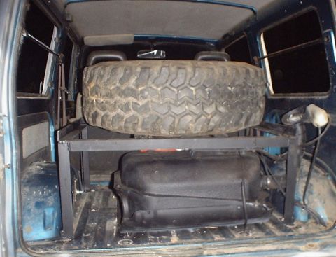 1989 Ford Bronco - Vehicle interior shows a spare tire and auxiliary fuel tank mounted on a custom rack.