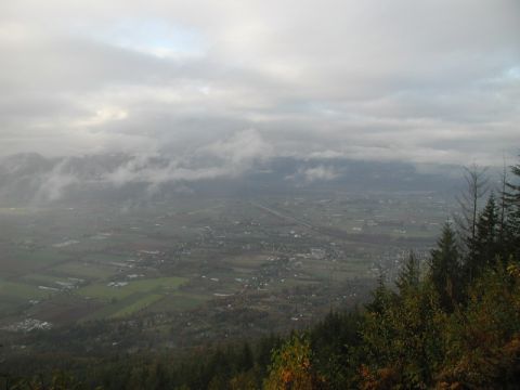 Valley with town and fields under a cloudy sky.
