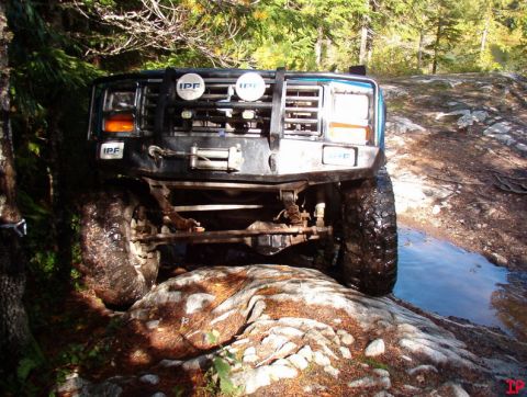 Blue off-road vehicle on rocks with winch and IPF lights