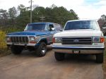 1989 Ford Bronco - A blue 1978 Ford Bronco is parked next to a white Ford F-Series truck.