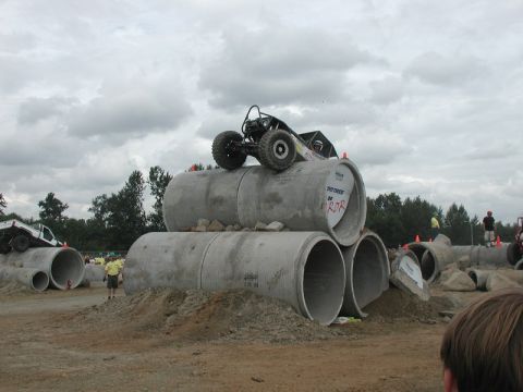 Custom off-road buggy on concrete pipes with another off-road vehicle in the background.