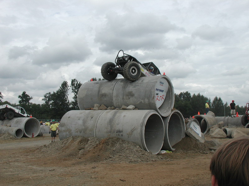 Custom off-road buggy on concrete pipes with another off-road vehicle in the background.