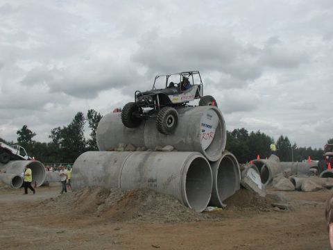 Custom off-road buggy on concrete pipes at an obstacle course.