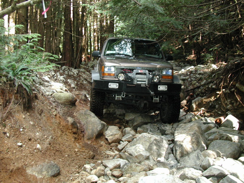 1985 Ford Bronco on a rocky trail in a forest