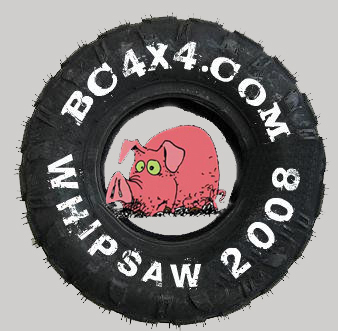 1985 Ford Bronco - A close-up of a tire with text that reads "BC4X4.COM WHIPSAW 2008" printed around the rim. A cartoon pig is visible in the center of the ti…