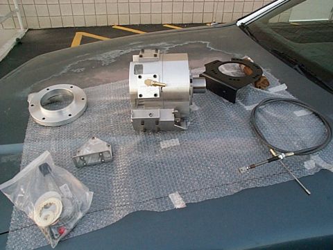 1994 Ford Bronco - Various automotive components are laid out on the hood of a car, suggesting a repair or upgrade in progress.