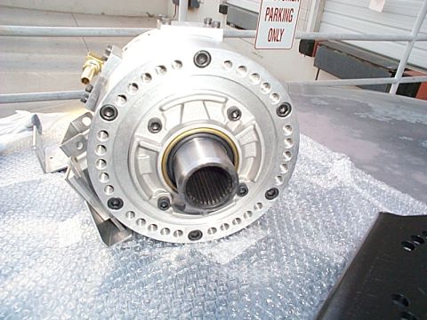 1994 Ford Bronco - Close-up of a transfer case component, a splined input shaft and a circular bolt pattern. Text on a sign reads 'PARKING ONLY'.