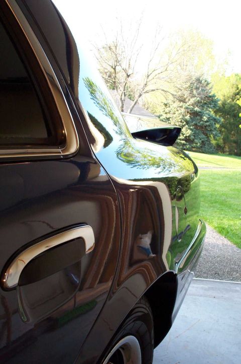 1998 Ford Crown Victoria - The rear quarter panel of a dark blue 1998 Ford Crown Victoria shows off its polished finish and chrome accents.