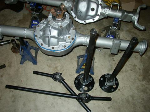 1995 Ford Bronco - Two rear axle assemblies and associated driveshafts are shown, supported by jack stands.