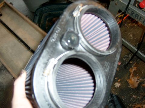 1995 Ford Bronco - A dual air filter housing is shown in detail, with a hand holding the part.