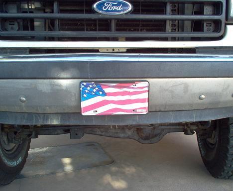 1988 Ford Bronco - Front view of a Ford truck, the grille and bumper with an American flag license plate.