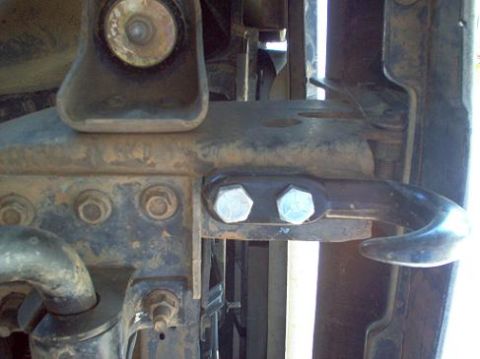 1988 Ford Bronco - Vehicle frame with a bolted tow hook assembly, showing signs of wear and rust.