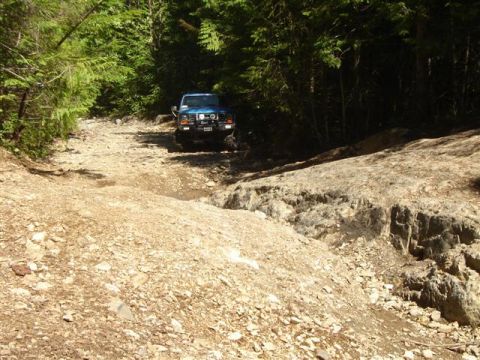 1985 Ford Bronco on a rocky, wooded trail.