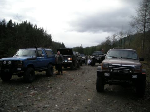 Blue 1985 Ford Bronco with snorkel modification parked on gravel road.