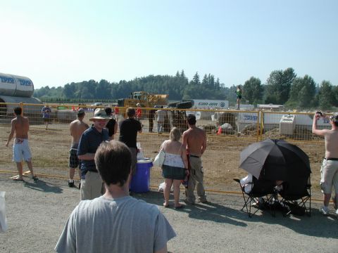 People gathered at an outdoor event with construction equipment in the background.