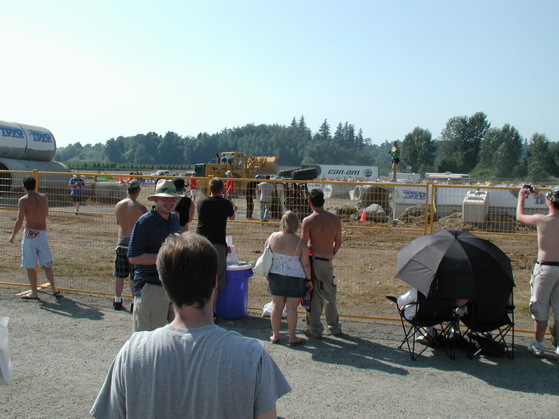 People gathered at an outdoor event with construction equipment in the background.