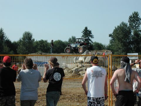Custom off-road buggy with roll cage on rocky obstacle course.