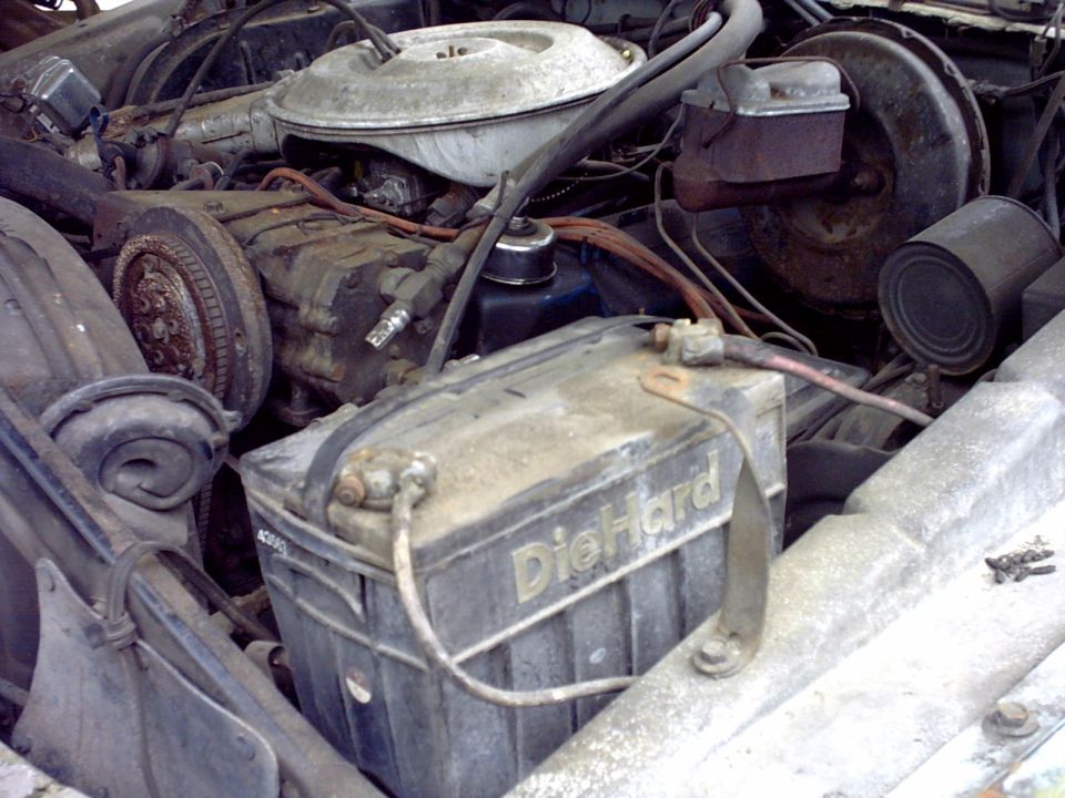 Dirty engine bay with corroded DieHard battery, air cleaner and brake booster visible