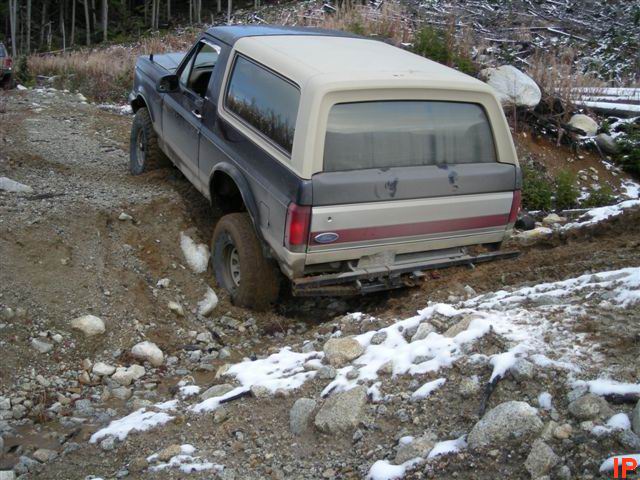 1985 Ford Bronco on a muddy, snowy trail.