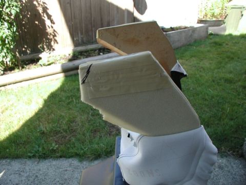 1990 Ford F-250 - A close-up view of a white shoe with the text "SNUG" visible on the side, attached to a light tan padded object that is taped with beige ta…
