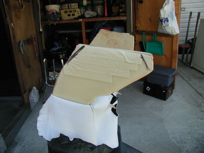 Custom foam padding with white fabric, taped and partially attached, in a garage setting.